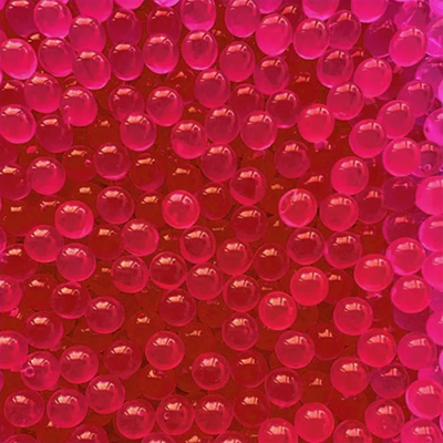 Close-up of pink Boba POPS pearls on a red background